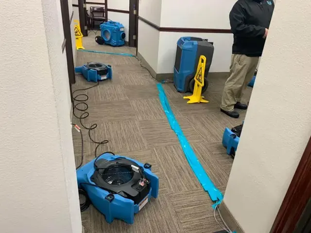 Air movers drying carpet along a hallway after a Vacaville water loss