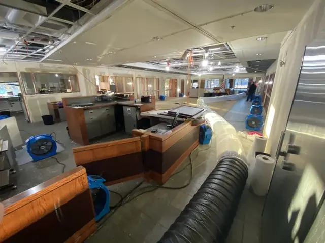 Drying equipment and duct set up across an open office space after a leak