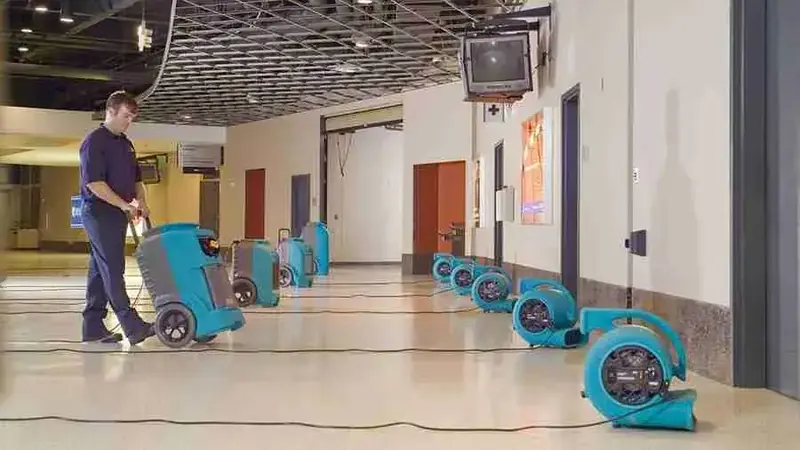 Air movers and a dehumidifier drying a long commercial corridor in Vacaville