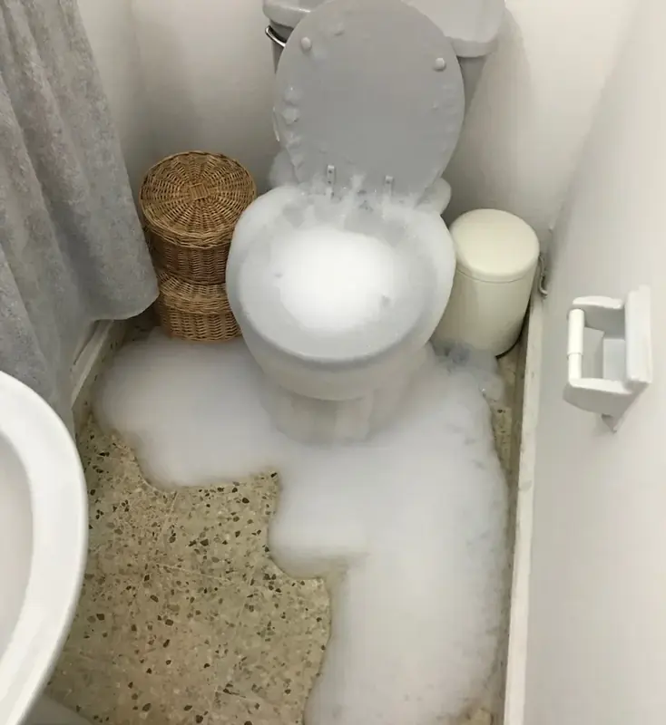 Overflowing toilet spilling water across a bathroom floor in Vacaville